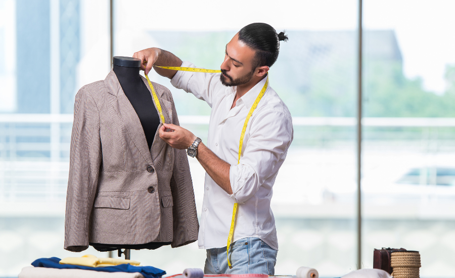 A man measuring a jacket on a mannequin for a perfect fit.